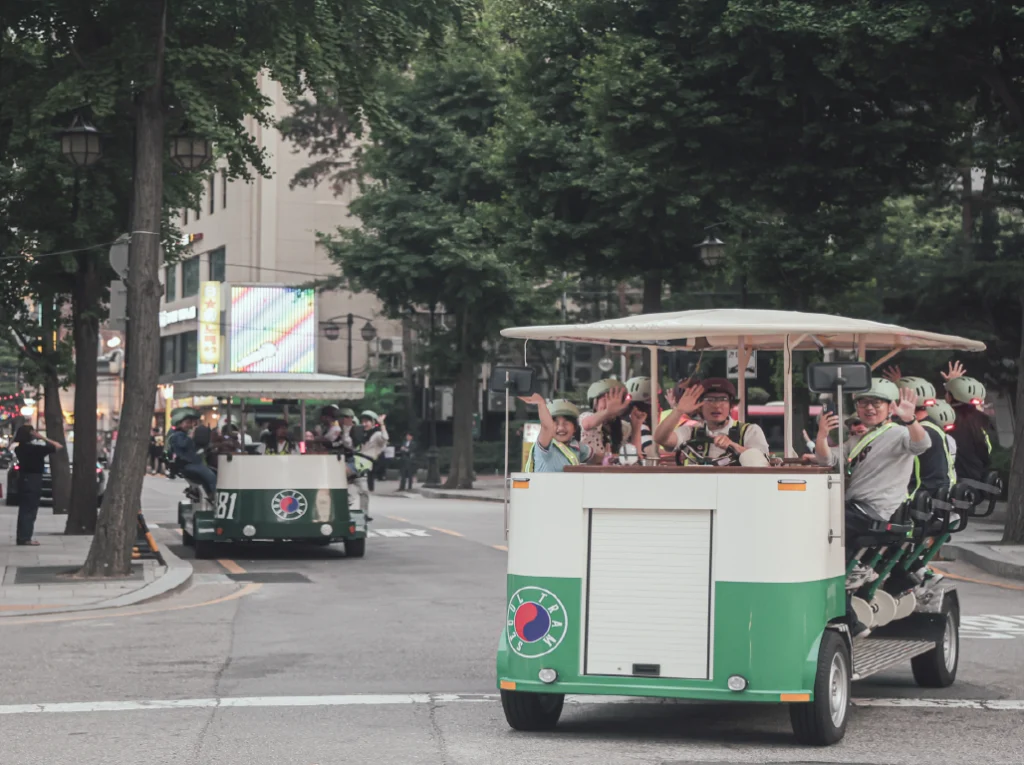 Happy tourists enjoying a fun Seoul Tram tour through the city. / 서울전차를 타고 서울을 즐겁게 여행 중인 관광객들.