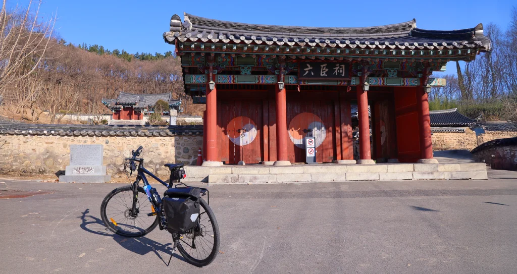 A touring bicycle parked in front of a traditional Korean gate at the historic Yookjo Shrine in Korea. / 한국의 유서 깊은 육조사 앞에 세워진 자전거 한 대.