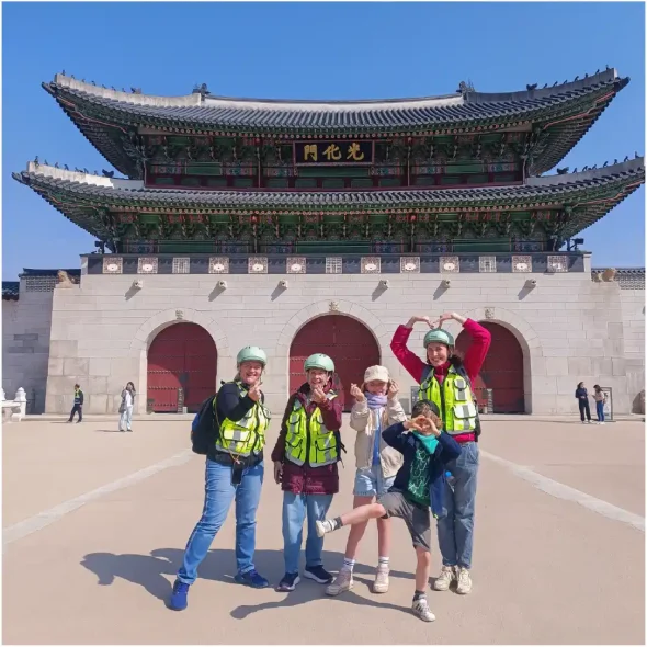 Tourists posing in front of Gwanghwamun Gate in Seoul during a city tour.