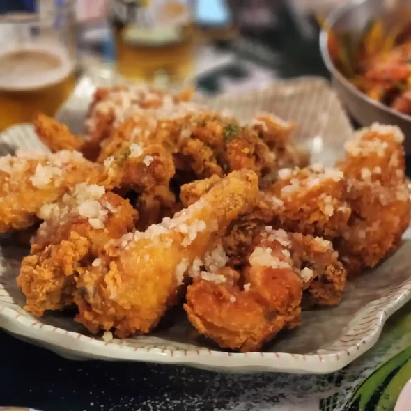 Tourist enjoying Korean fried chicken at an outdoor restaurant in downtown Seoul after a city tour.